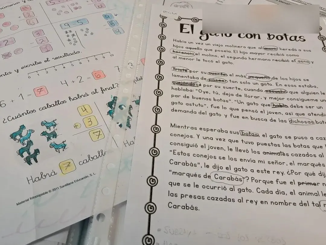 Fichas de matemáticas y de comprensión lectora corregidas, sobre la mesa de trabajo
