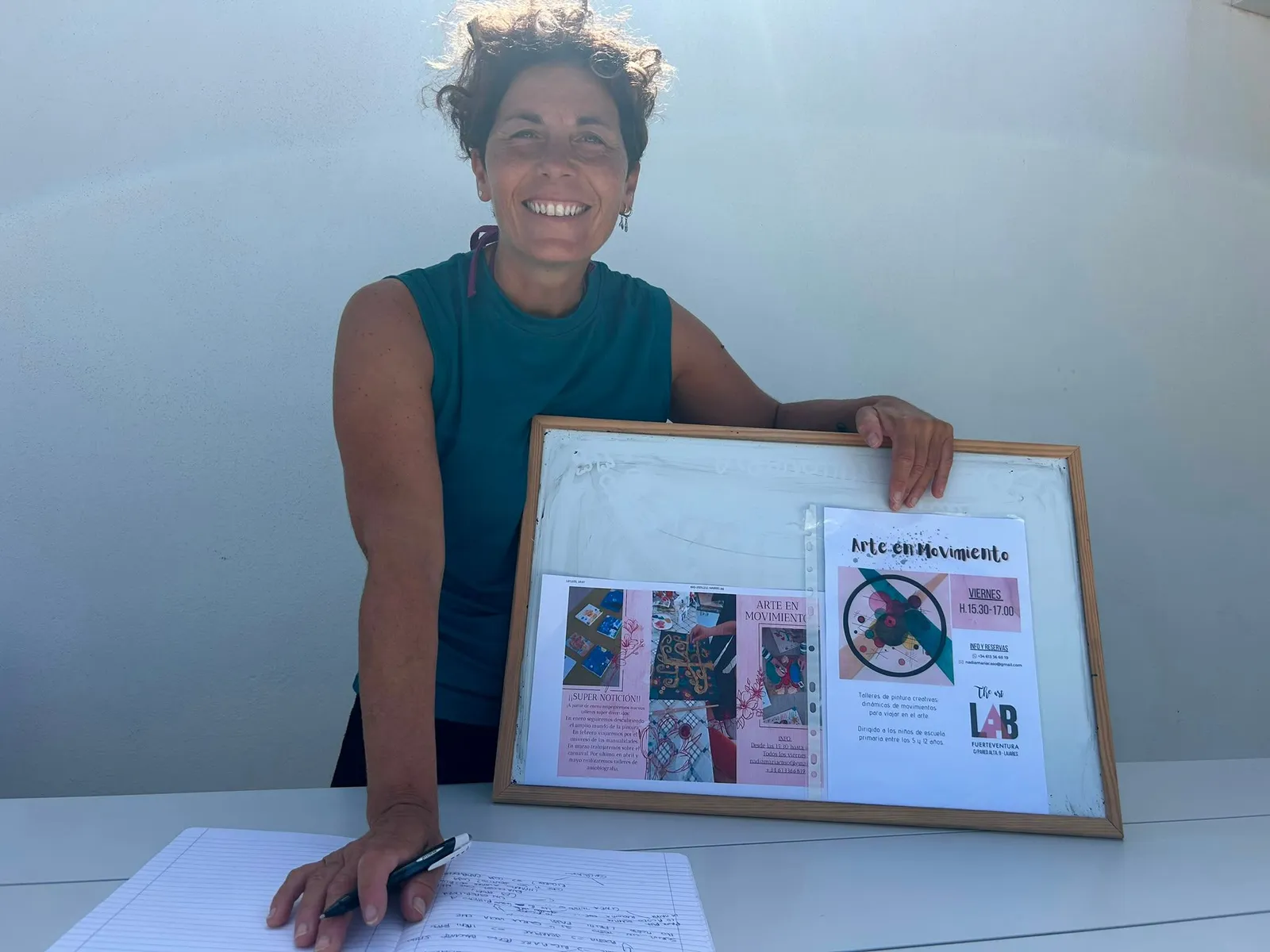 Nadia muestra el tablón con el cartel de Arte en Movimiento y The Art Lab