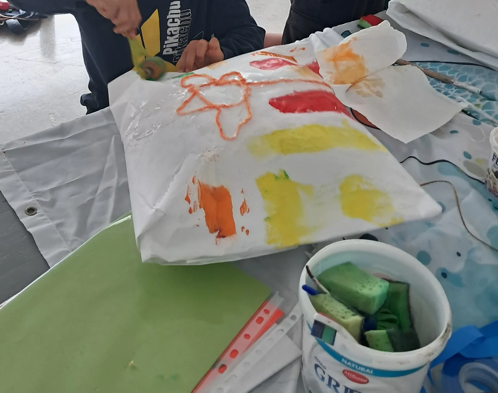 Almhoda de papel: un niño decora una flor en su almohada. Bienvenida Primavera
